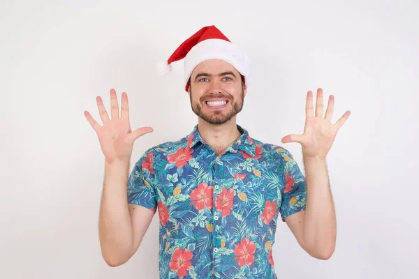 头戴圣诞礼帽的年轻人面带微笑 带着自信和快乐 手指点点十号 — 图库照片