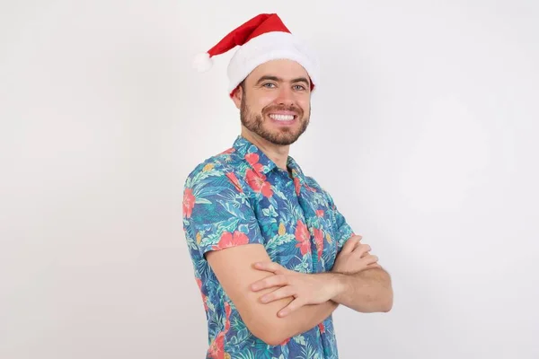 Jonge Man Met Kerstmuts Glimlachend Met Gekruiste Armen Kijkend Naar — Stockfoto