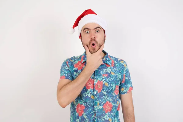 Noel Baba Şapkalı Genç Adam Elleri Çenesinde Inançsızlığa Şaşkınlığa Hayrete — Stok fotoğraf