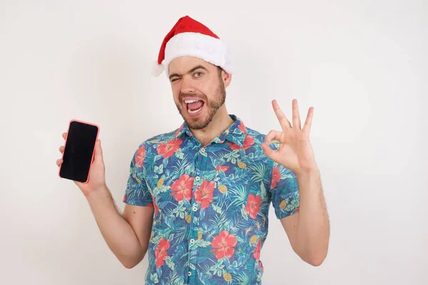 Akıllı Telefondan Poz Veren Noel Baba Şapkalı Yakışıklı Bir Genç — Stok fotoğraf