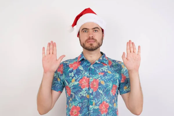 头戴圣诞礼帽的年轻人把手掌拉向摄像机 做停止动作 要求控制你的情绪 不要紧张 — 图库照片