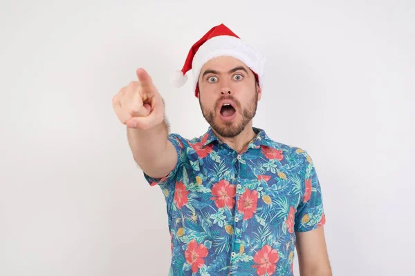 Noel Baba Şapkalı Genç Adam Parmağıyla Işaret Ederek Şaşırdı Ağzı — Stok fotoğraf
