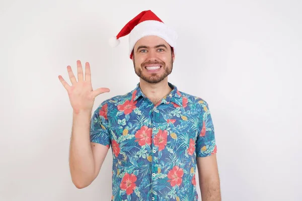 Noel Baba Şapkalı Genç Adam Beş Numarayı Gösterip Işaret Ederken — Stok fotoğraf
