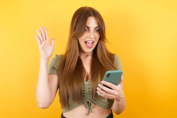 Beautiful Young Woman Posing Modern Smartphone Yellow Studio Background — Stock Photo, Image