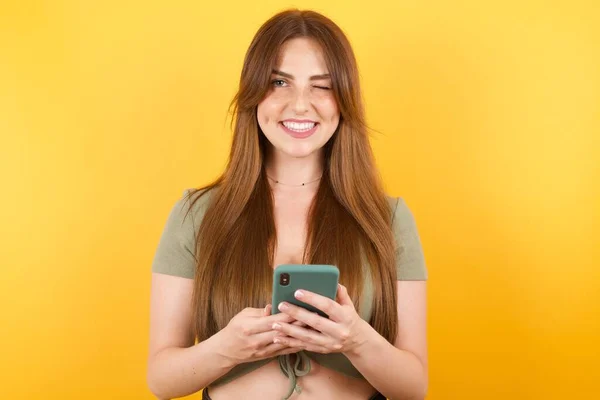 Beautiful Young Woman Posing Modern Smartphone Yellow Studio Background — Stock Photo, Image