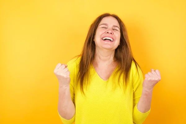 美丽而成熟的女人对成功感到惊奇 她举起双臂 闭上眼睛 赢的概念 — 图库照片