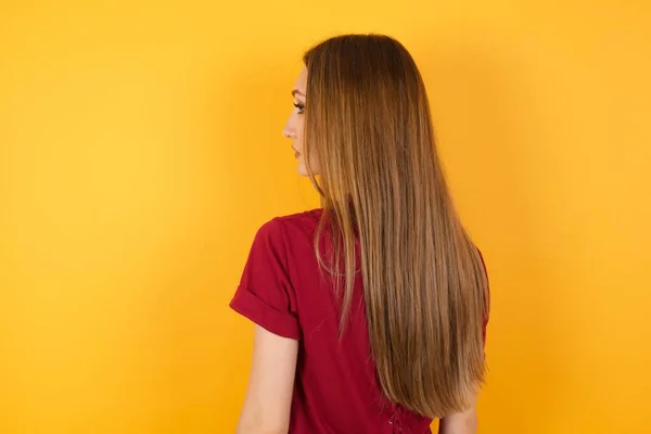 Sarı Duvarın Önünde Duran Güzel Genç Bir Kadın Stüdyo Çekimi — Stok fotoğraf