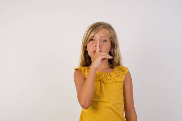 cute little girl asking to be quiet with finger on lips. Silence and secret concept.