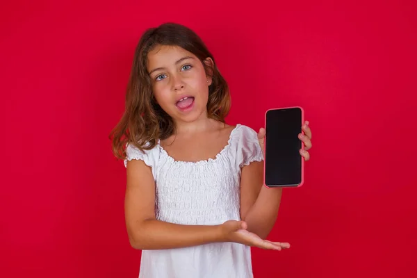 Menina Bonito Com Smartphone Posando Fundo Estúdio Vermelho — Fotografia de Stock