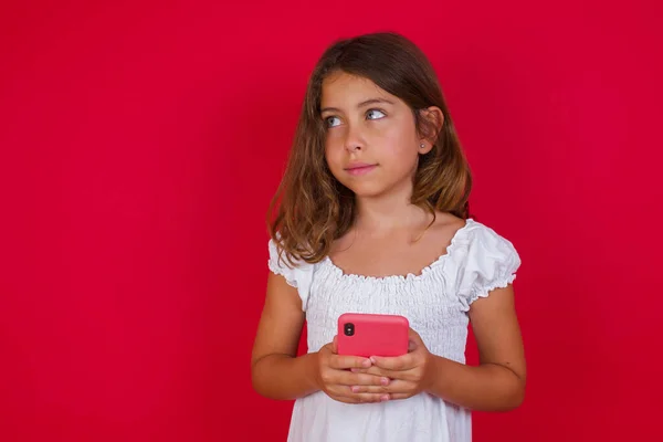 可愛いです女の子とともにスマートフォンポルノの赤いスタジオの背景 — ストック写真