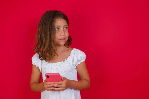 可愛いです女の子とともにスマートフォンポルノの赤いスタジオの背景 — ストック写真