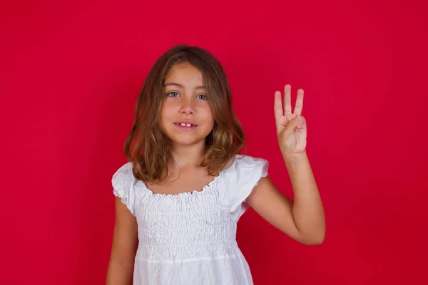自信と幸せ笑いながら指の数3を表示し 指差す小さなCaucasian女の子 — ストック写真