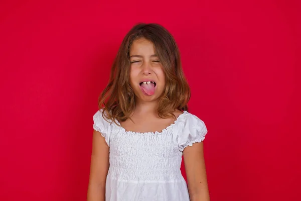 Little caucasian girl  sticking tongue out happy with funny expression. Emotion concept.