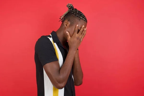 crying African american black man in studio covering face with hands