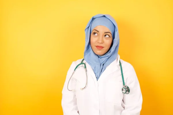 Fiatal Doktornő Orvosi Egyenruhát Visel Félrenéz Üres Térben Gondolkodó Elszigetelt — Stock Fotó
