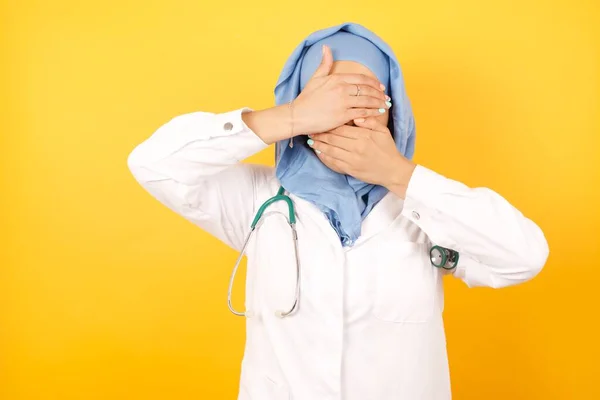 Jovem Médica Vestindo Uniforme Médico Cobrindo Olhos Boca Com Mãos — Fotografia de Stock