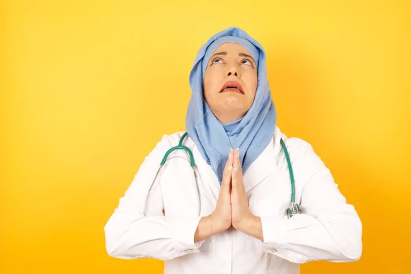 Νεαρή Γυναίκα Γιατρός Φορώντας Ιατρική Στολή Επαιτεία Και Προσεύχεται Χέρια — Φωτογραφία Αρχείου