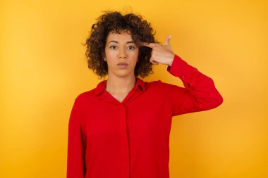 Güzel genç bir kadın dudaklarını kıvırıyor ve intihar jesti yapıyor, her şeyden bıkıyor, sinagogda elle çekim yapıyor, stüdyo arka planında izole edilmiş..