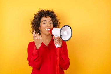 Megafonlu genç bayan, gel buraya. El kol hareketi yap. Mutlu bir şekilde karşıla ve gülümse.