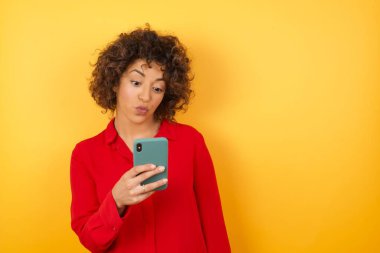 Güzel genç bayan yeni akıllı telefon kullanıyor.