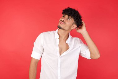 Genç yakışıklı adamın kafası karışıyor ve soru sormayı merak ediyor. Şüpheyle kararsız, kafa kafaya düşünerek. Düşünceli kavram.