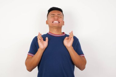 Umut ve gözlerin kapalı gülümseyen, el işareti yapan yakışıklı genç adam. Şans ve batıl inanç..