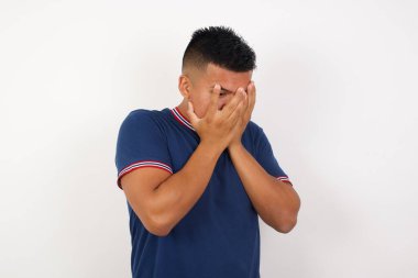 Stüdyoda ağlayan adam elleriyle yüzünü kapatıyor. 