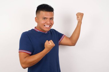 Yakışıklı genç adam yumruk kaldırıyor.  