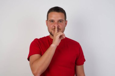 Kafkasyalı genç adam sessiz olmak istiyor, parmakları dudaklarında. Sessizlik ve gizli konsept.