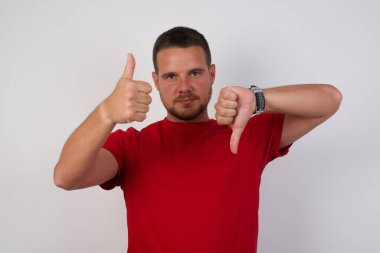 Adam baş parmağını kaldırıyor ve baş parmaklarını indiriyor. Zor seçim.  