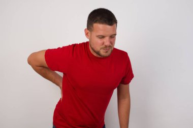 Adam sırt ağrısı çekiyor, elleriyle dokunuyor, kas ağrısı çekiyor.