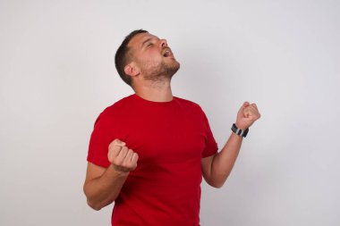 Adam kolları havada ve gözleri kapalı bir şekilde başarıyı kutluyor, şaşırıyor ve şaşırıyor. Kazanan konsept.