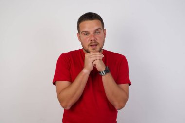 Kafkasyalı genç adam elleri yüzü çaprazlanmış dua ediyor, şaşırmış ve ağzını açmış. 