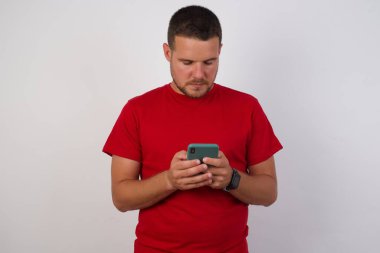 Beyaz arka planda izole edilmiş, cep telefonu tutan beyaz adam portresi 