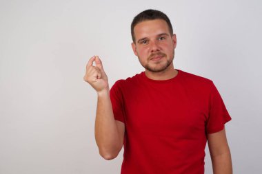 Kırmızı tişörtlü yakışıklı genç adam elini kaldırdı ve kameraya baktı. 