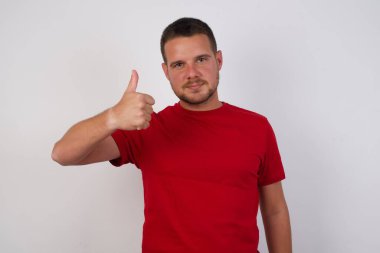 Adam elleriyle mutlu bir jest yapıyor. Kameraya bakıp başarıyı gösteren ifade onaylanıyor.