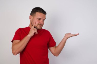 Komik yakışıklı adam yeni ürün için elini açık tutuyor. 