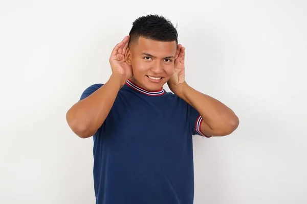 Όμορφος Νεαρός Που Προσπαθεί Ακούσει Και Δύο Χέρια Χειρονομίες Αυτιών — Φωτογραφία Αρχείου