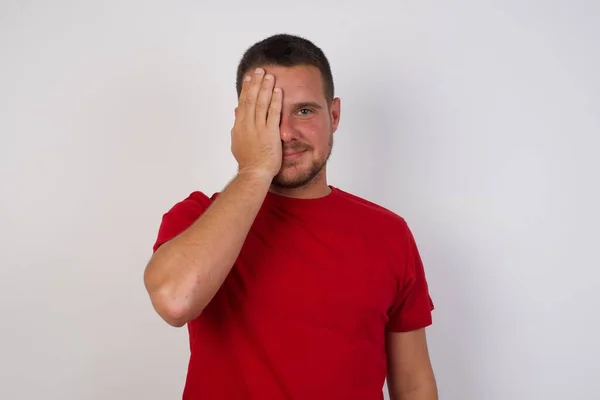 Esmer Adam Kırmızı Tişört Giyiyor Bir Gözünü Eliyle Kapatıyor Yüzünde — Stok fotoğraf