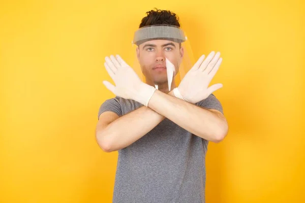 Άνθρωπος Προστατευτικό Καπέλο Κίτρινο Στούντιο Έχει Έκφραση Απόρριψης Διασχίζει Χέρια — Φωτογραφία Αρχείου