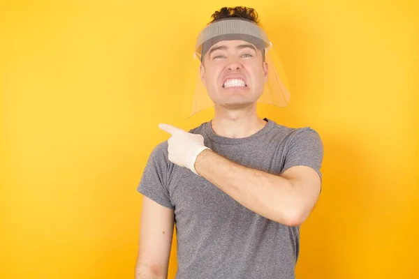 Jovem Caucasiano Vestindo Camiseta Protetor Facial Sobre Fundo Amarelo Isolado — Fotografia de Stock