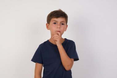 Gergin, şaşkın, sıradan tişörtler giyen, izole edilmiş beyaz arka plan üzerinde duran, sürprizden ağzı açan, ani haberlere tepki veren güzel bir çocuğun vesikalığı. İnsanlar ve yüz ifadeleri.