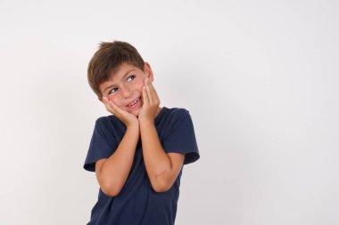 İzole edilmiş beyaz arka planda dikilen sıradan tişörtler giyen güzel bir çocuktan esinlenilmiştir. Kopyalama alanına bakıp gelecekle ilgili düşünceleri vardır. 