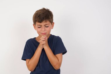 Üzgün ve güzel bir çocuk, izole edilmiş beyaz arka planda duran sıradan bir tişört giyiyor, üzgün yüz ifadesi ve duygu konsepti yüzünden acı ve depresyon çeken, gözü yaşlı ve bunalımlı bir çocuk.