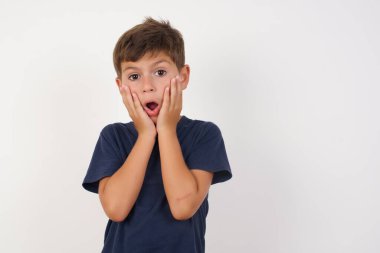 İzole edilmiş beyaz arka planda dikilen sıradan tişört giyen güzel bir çocuğun atölyedeki fiyatlarla şok olmuş, bir şey alacak parası kalmamış, insan ve insan duyguları kavramı.