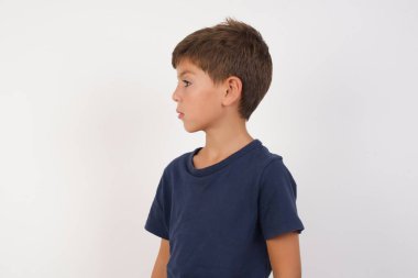 Yan profil fotoğrafını çek. Güzel çocuk günlük tişörtler giyiyor. İzole edilmiş beyaz arka planda duruyor..