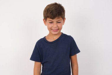 İzole edilmiş beyaz arka planda dikilen, dişlerini sıkan, tatminsizlikten kaşlarını çatan, görevleri yüzünden tedirgin olan, sıradan tişört giyen öfkeli güzel çocuk portresi. Öfkeli adam pencereden dışarı bakar, sefil havayı görür.