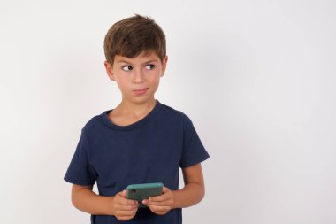 Güzel çocuk, günlük tişört giyiyor, beyaz arka plan üzerinde duruyor, el ele tutuşuyor, iyi gençlik haberleri okuyor, boş yer ilanı veriyor. 