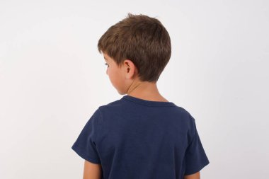 İzole edilmiş beyaz arka planda duran, günlük tişörtler giyen güzel bir çocuğun arka plan görüntüsü..