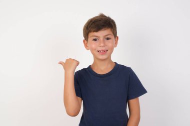 Güzel çocuk, izole edilmiş beyaz arka planda duran, fotokopi uzayını gösteren, indirimli beyaz tişörtler giyen, 